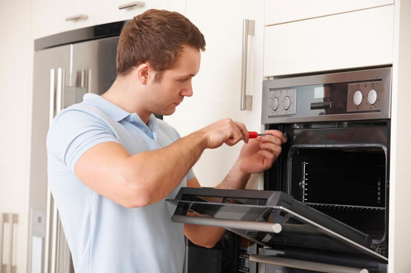 PURCHASING_APPLIANCE_INSURANCE Licensed service provider fixing an oven covered by a home warranty company