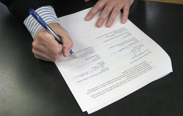 man signing home warranty documents