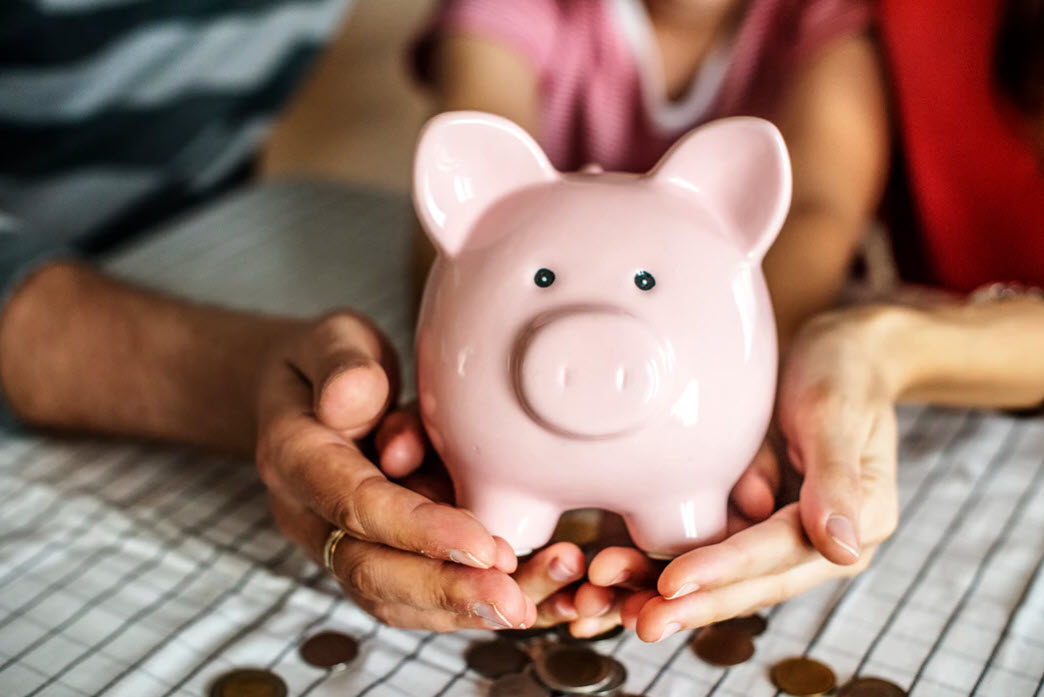 couple holding piggy bank and saving money for house