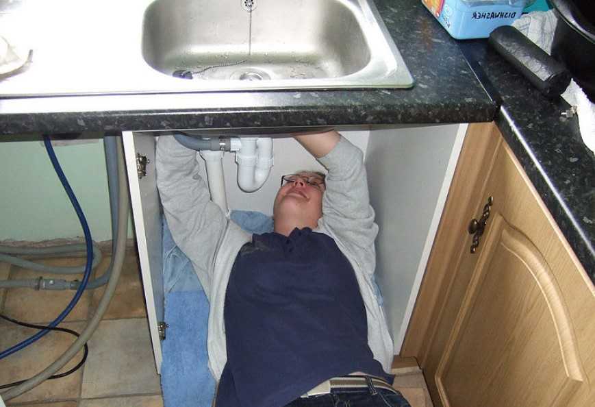 woman fixing sink at home