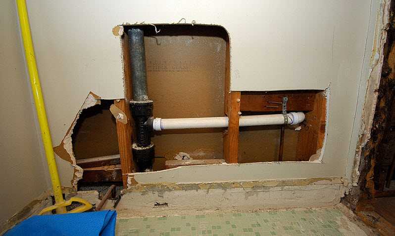 wall cutout of bad plumbing in house